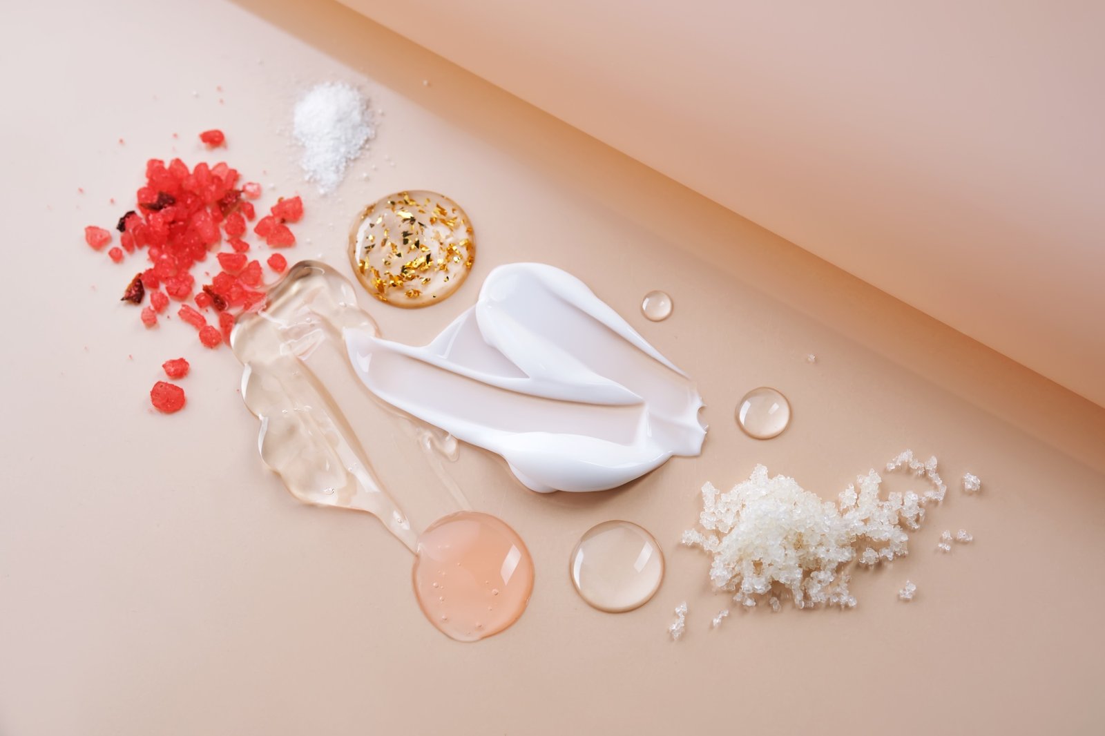 Different textures of cosmetic products on a beige background.