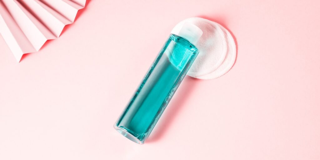 Skin care toner bottle on pink geometrical background